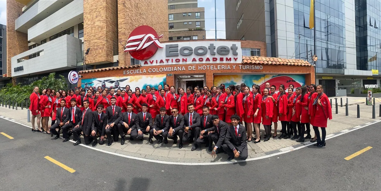 Estudiantes de la carrera de azafata y tripulante de cabina de ECOTET con uniforme frente a la sede en Bogotá