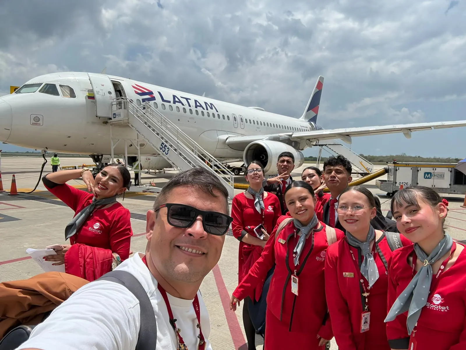 Estudiantes de aviación junto a avión comercial