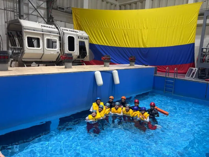 Estudiantes de ECOTET con chaleco salvavidas y casco en la piscina del simulador de ditching de la Armada de Colombia