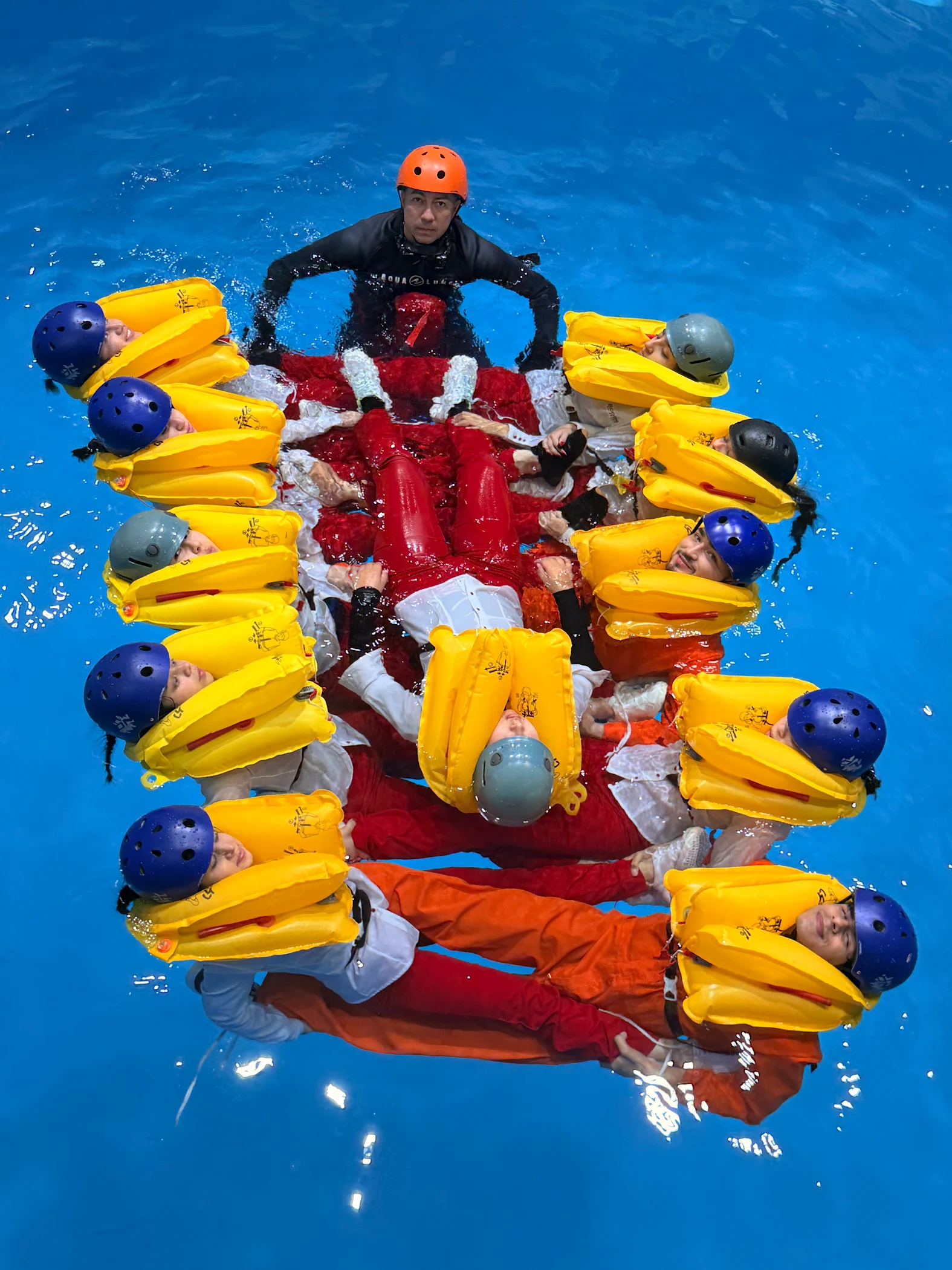 Estudiantes de ECOTET con chaleco salvavidas en formación de círculo en la piscina durante el entrenamiento en el agua
