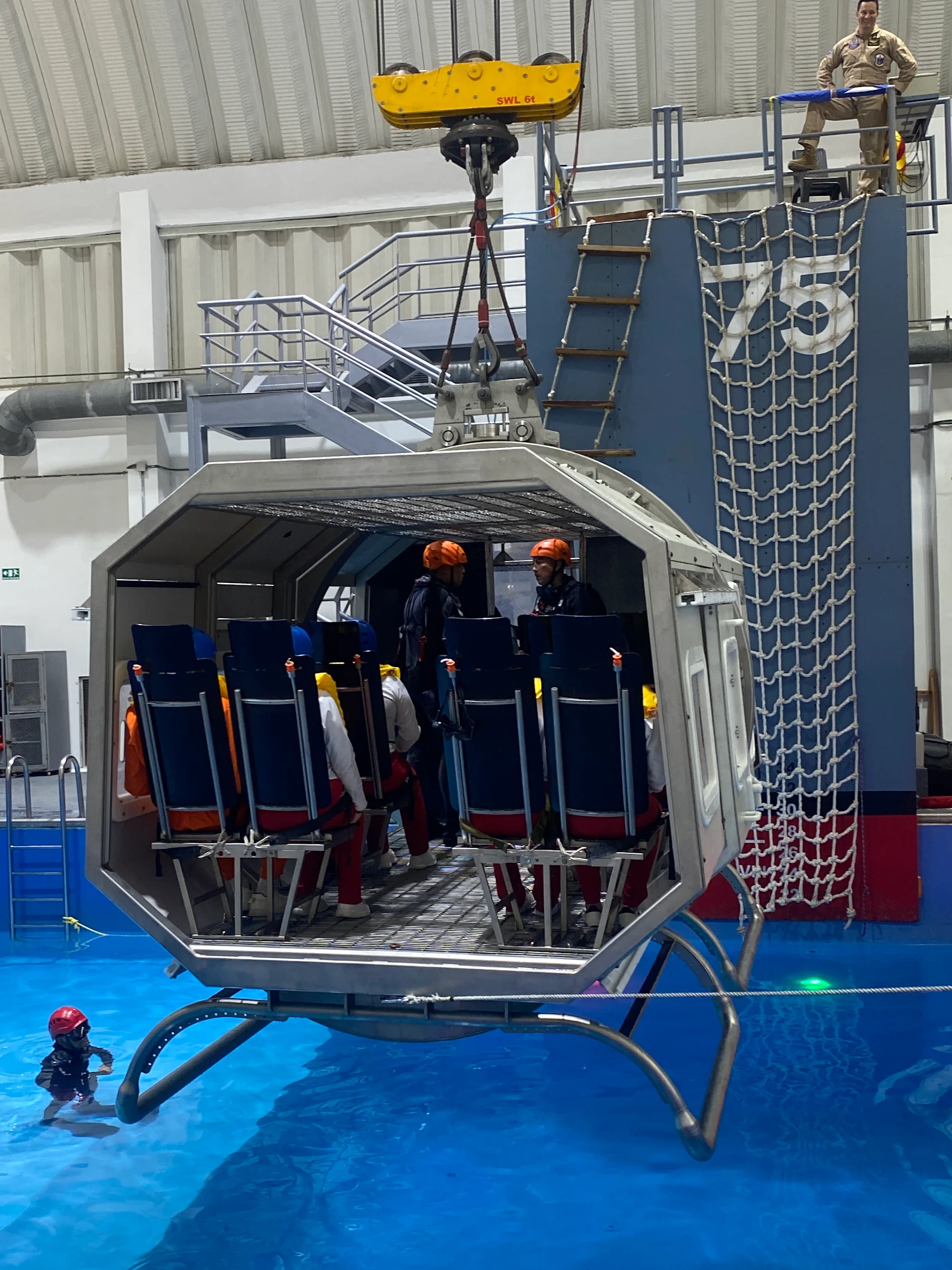 Simulador de cabina suspendido sobre la piscina durante la práctica de ditching de ECOTET